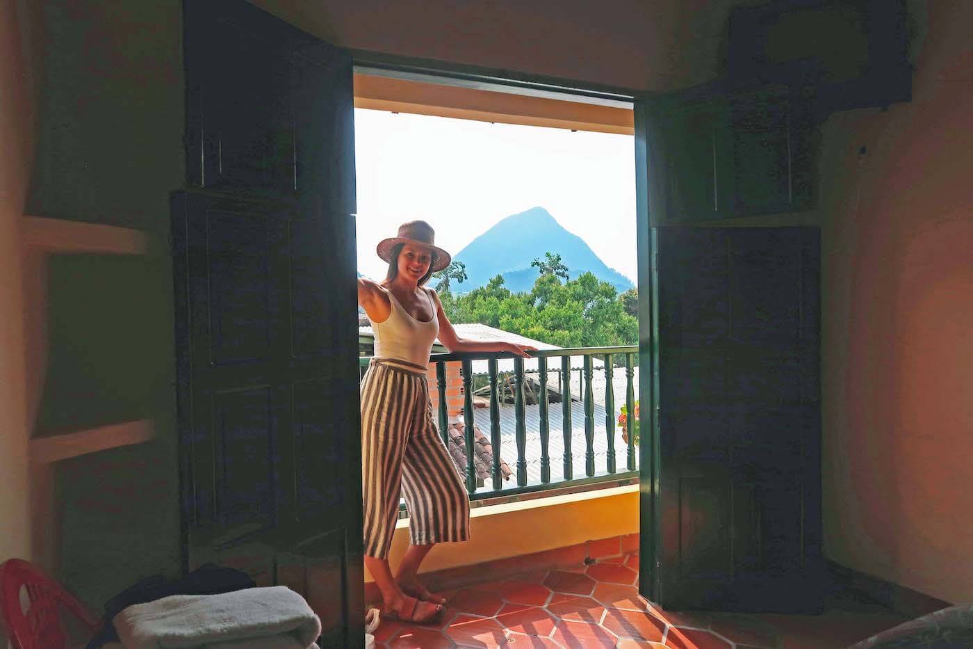 Kim standing by patio of our room in Hotel la Vereda with Cerro Tusa in background