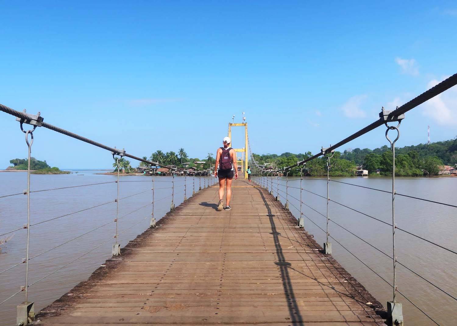 Kim walking on bridge over river