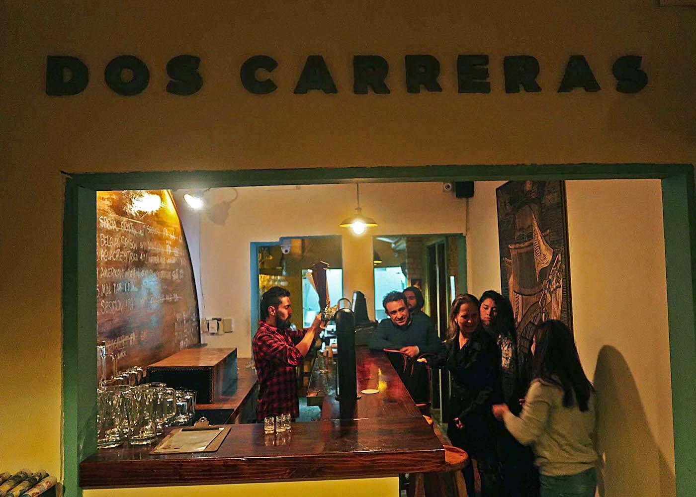 People at the bar and bartender at Dos Carreras microbrewery in Bogota