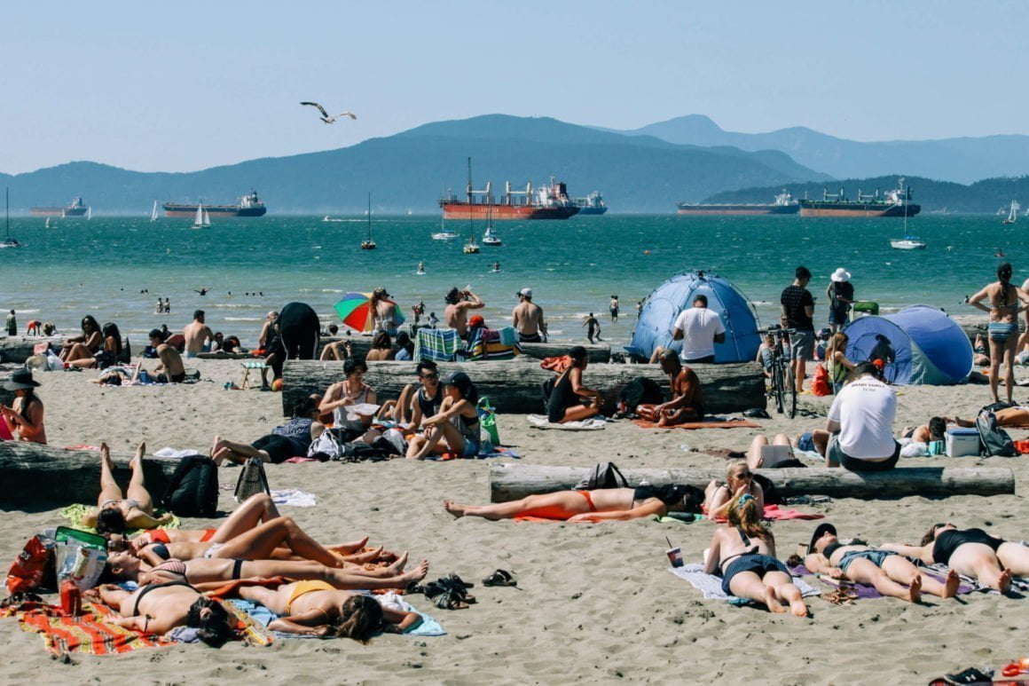 people tanning on busy kits beach in vancouver