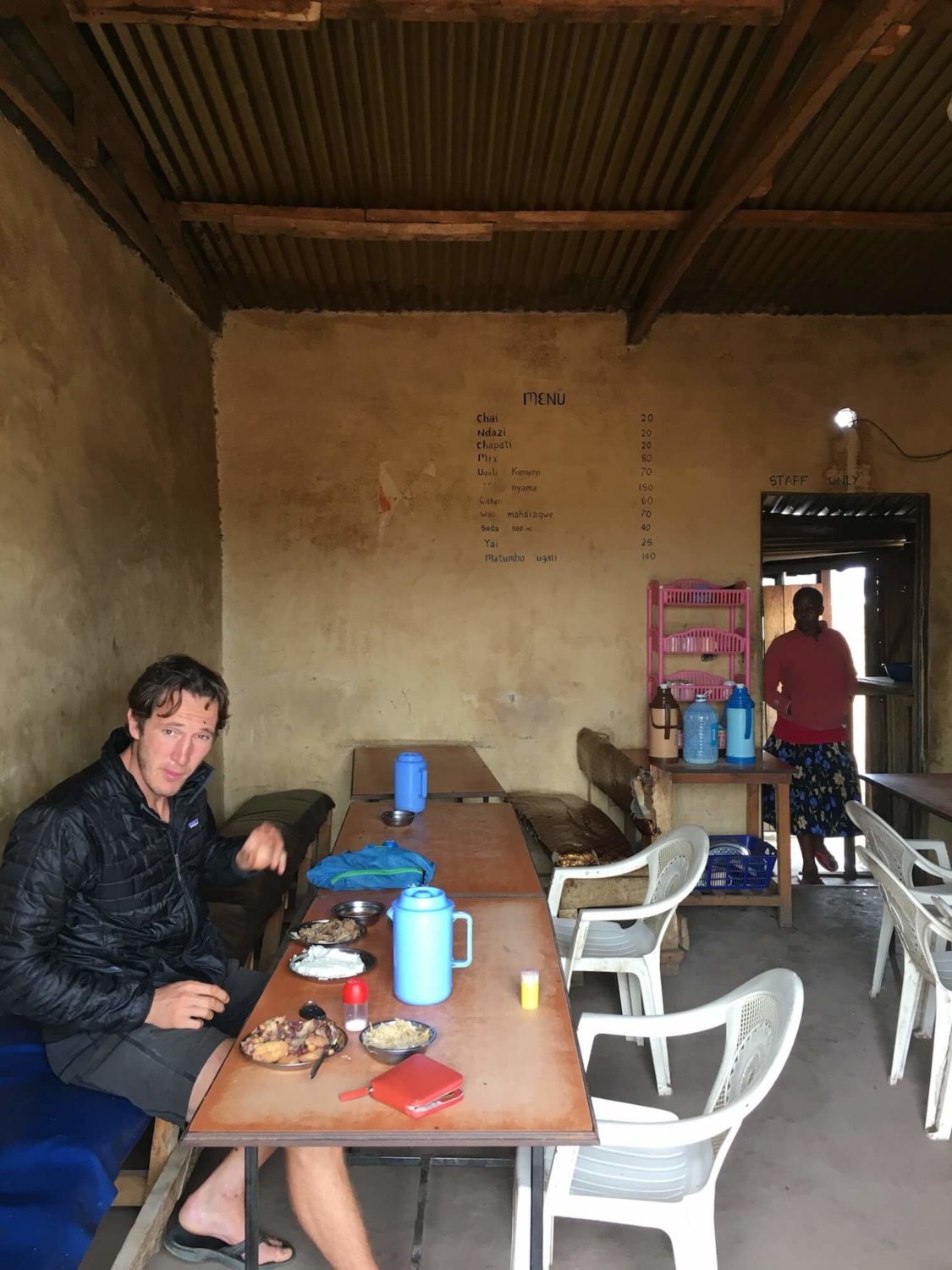 Chris eating a meal in a shack in Kenya
