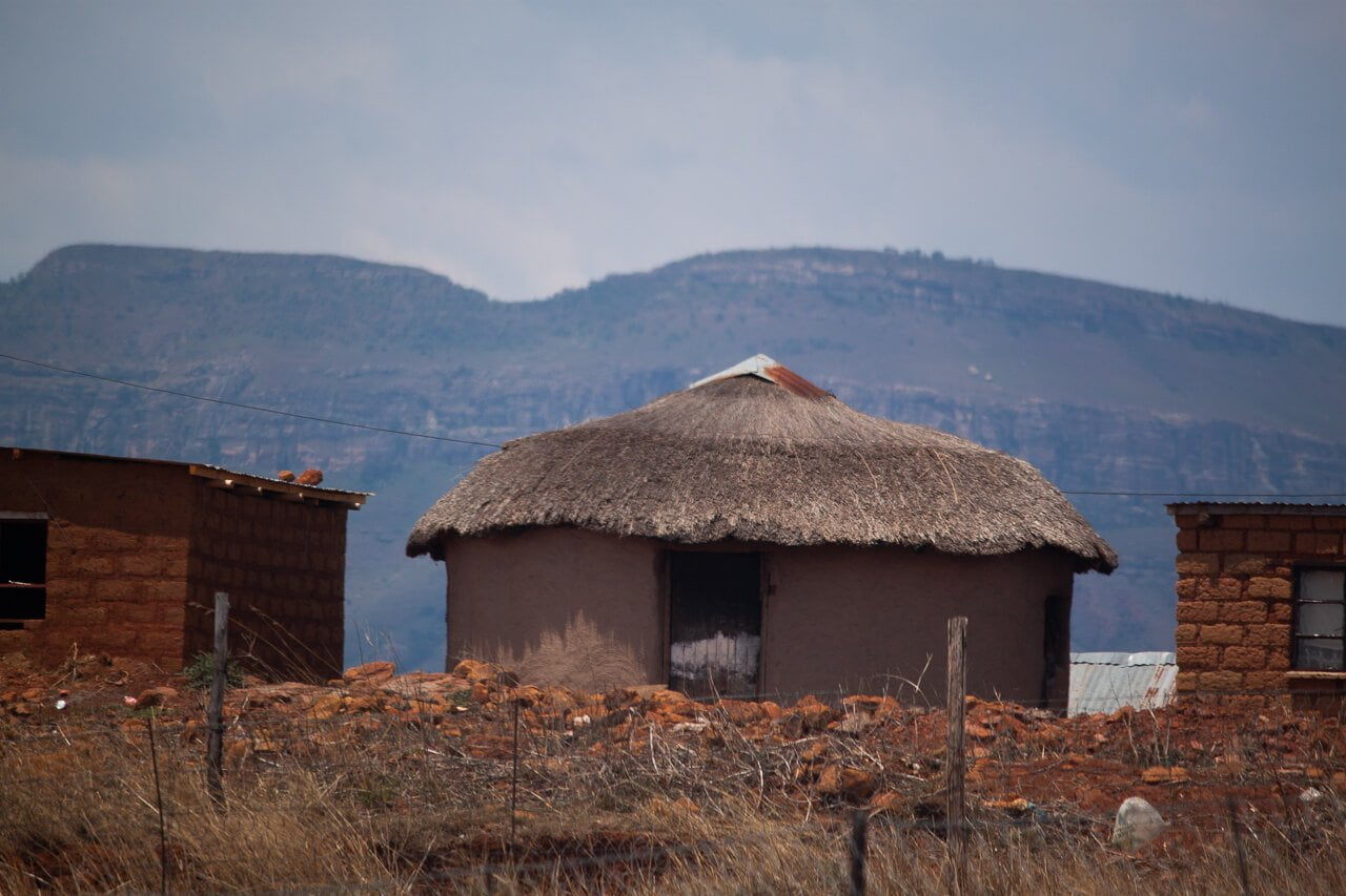 rural house made out of clay and thatched roof outside of drakensberg