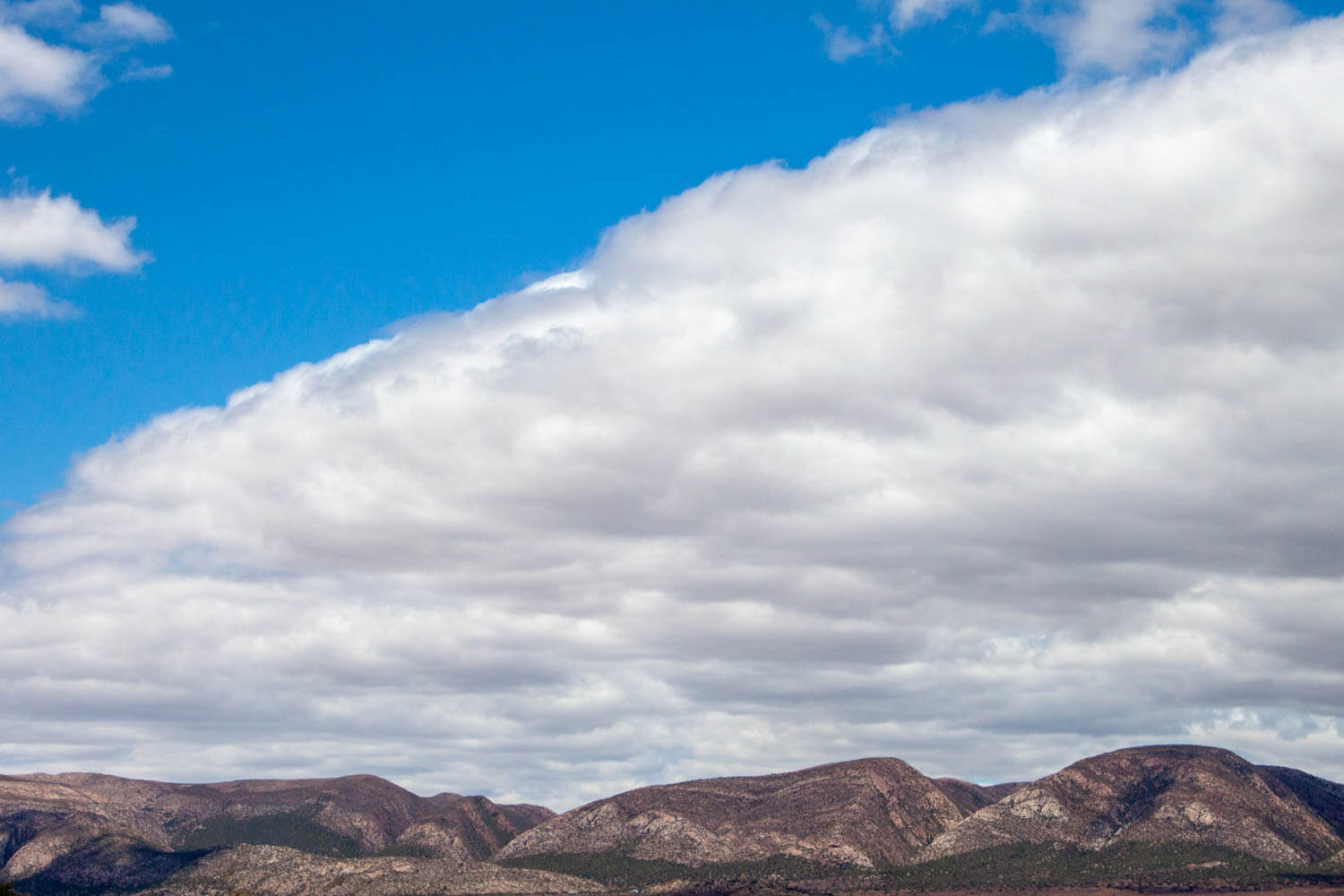 Cloud formation above desert mountains
