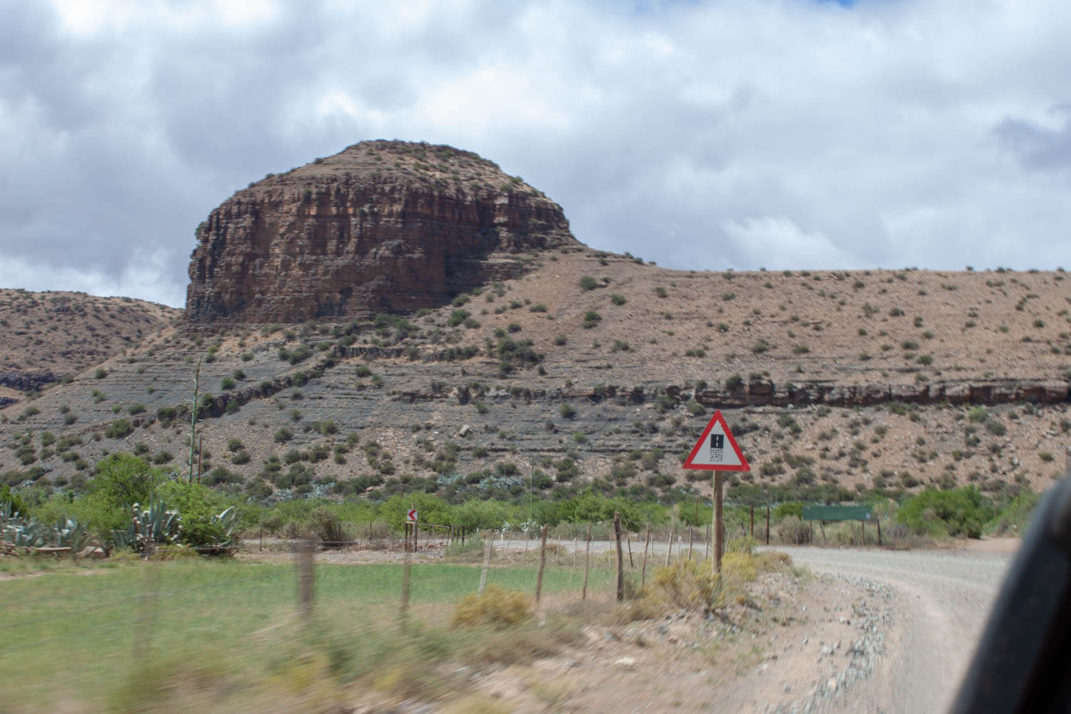Karoo desert and sign warning of winding roads