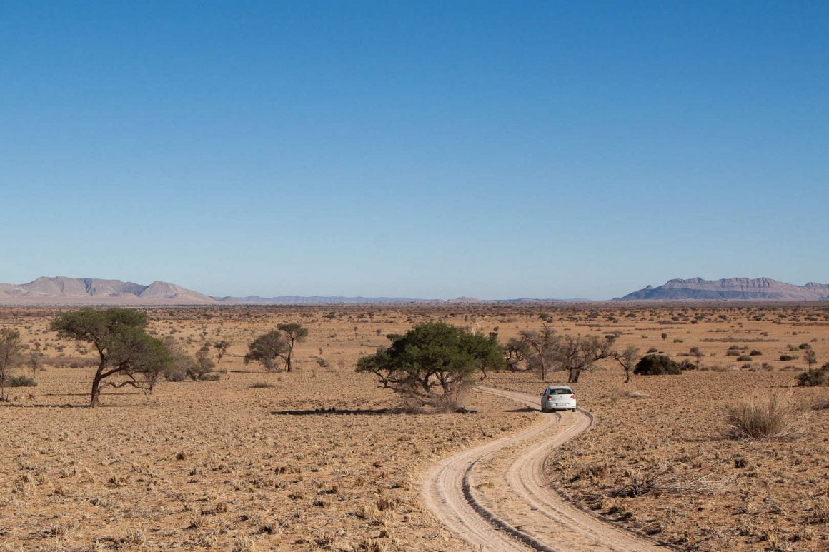 Our VW polo drives along an empty dirt and sand road by Gecko Camp