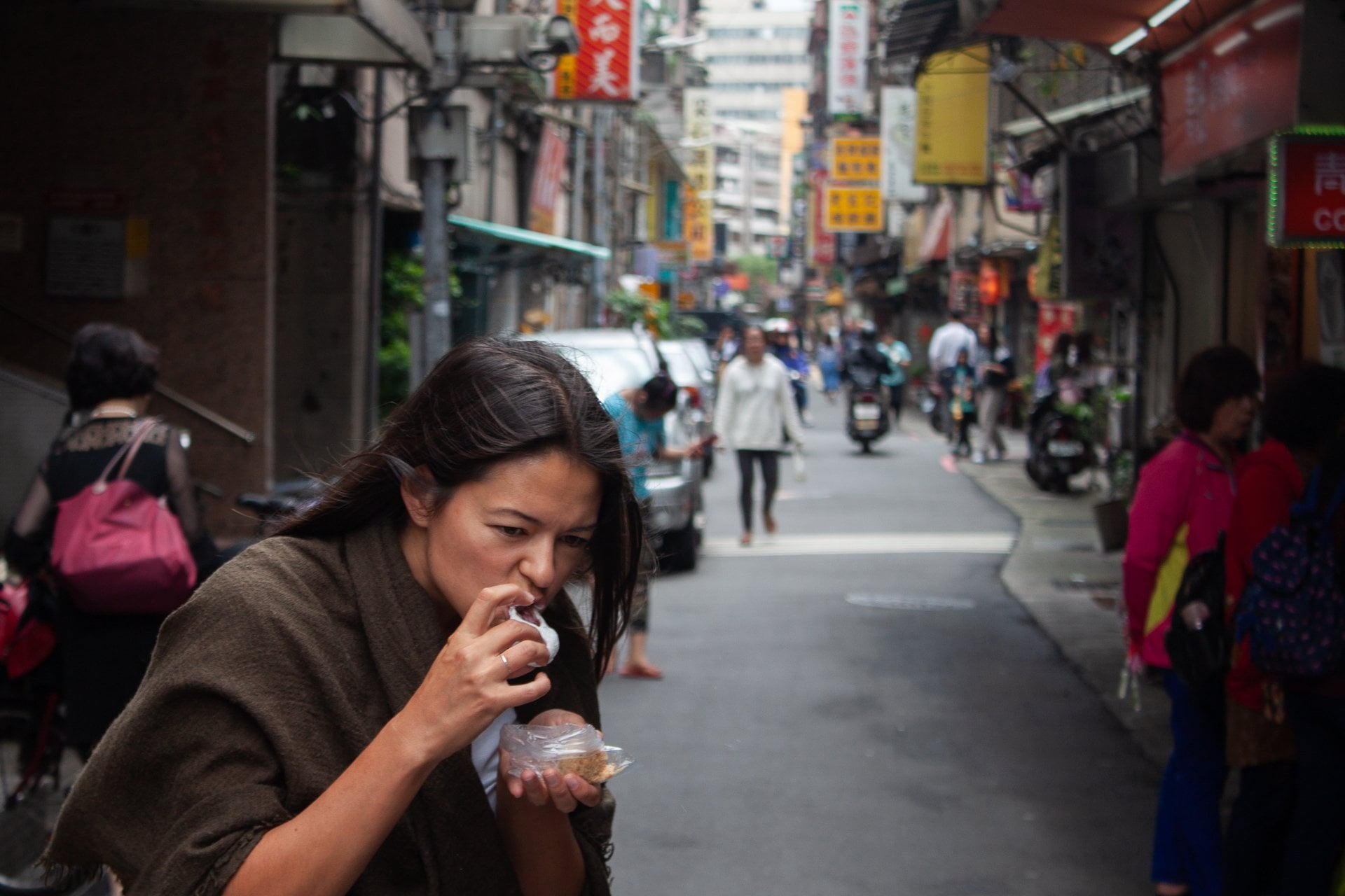 Cover image of Taipei 24 hour layover post. Kim eating on street.