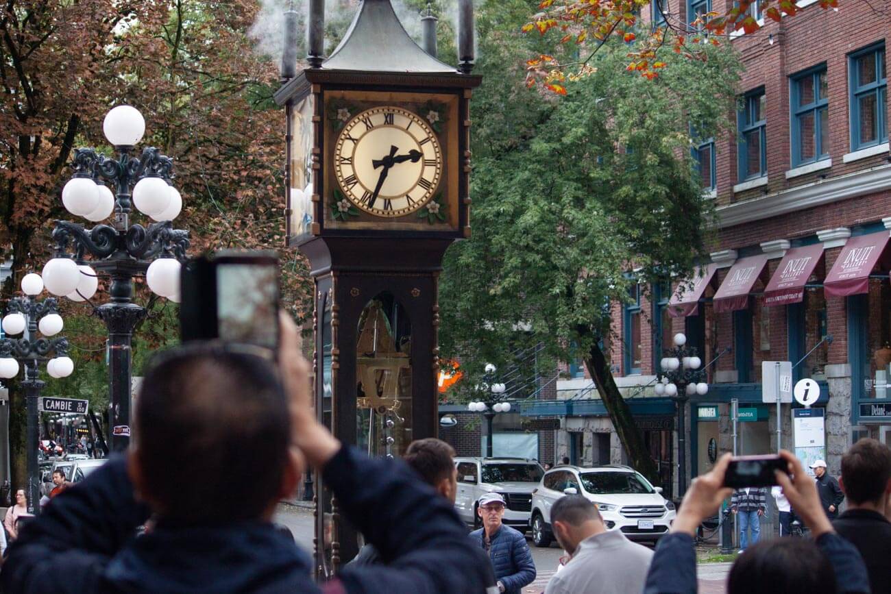 Tourists taking photos of the famous steam clock in Gastown