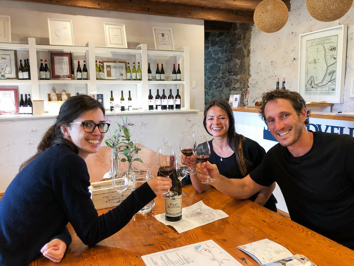 Rebecca, Kim, and Chris taste wine and cheers at Strandveld