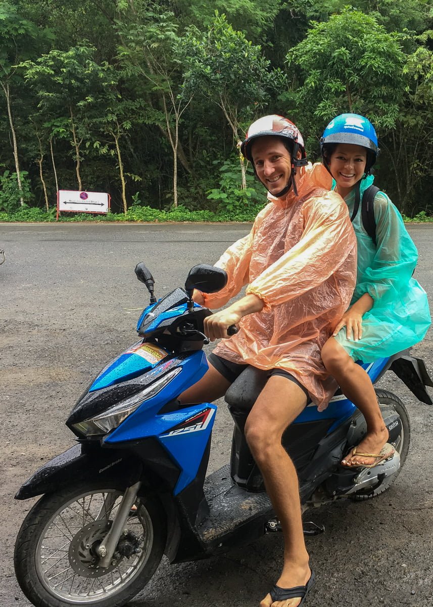 Chris and Kim on a motorycle wearing plastic raincoats