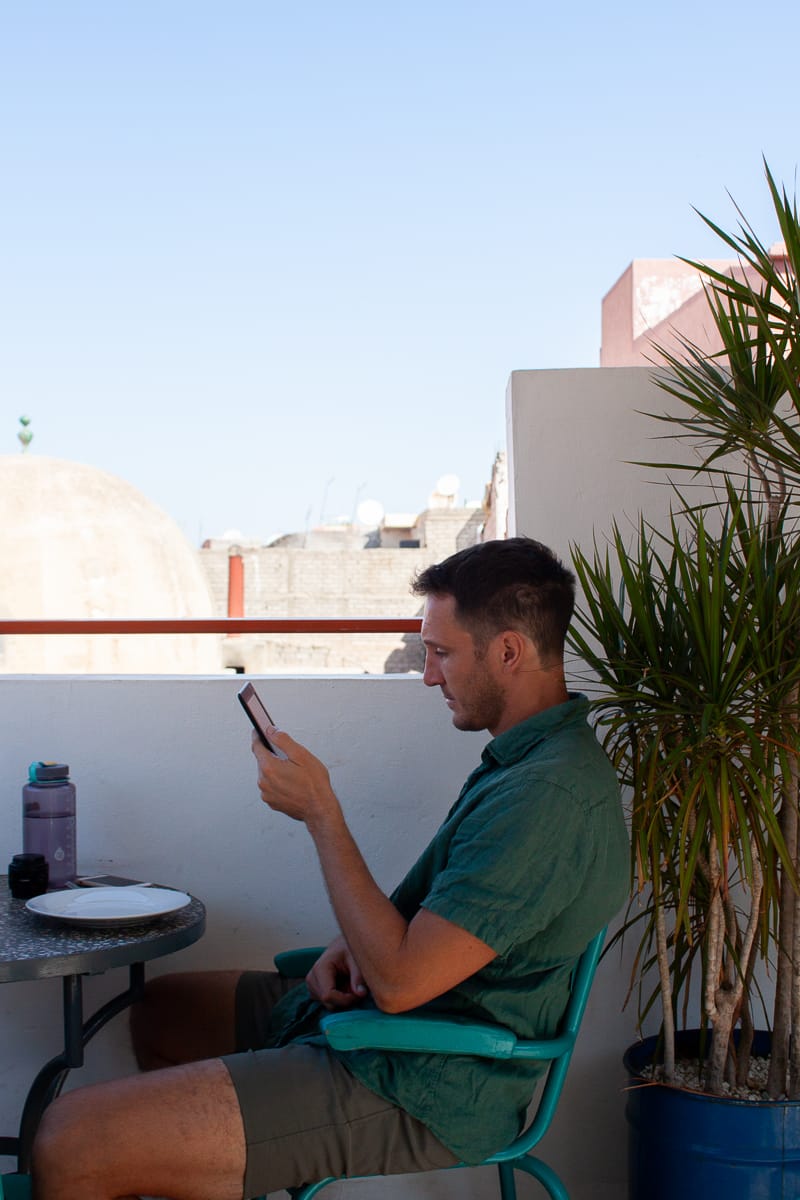 Chris reading his kindle at a cafe in Marrakech.