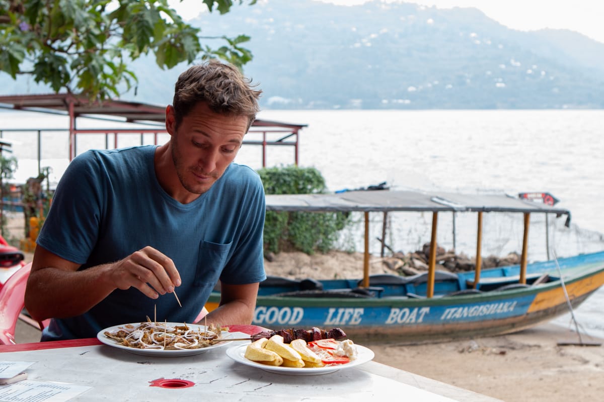 Chris eats sambaza at Lake Kivu